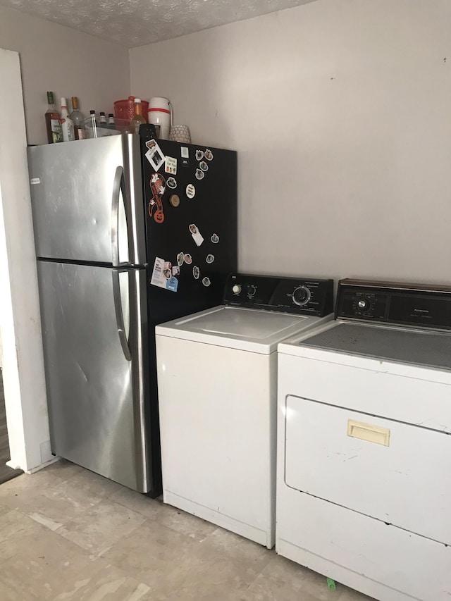 laundry room with washer and dryer and a textured ceiling