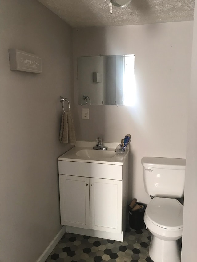 bathroom with vanity, a textured ceiling, and toilet