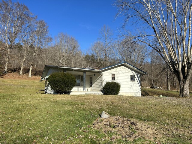 view of home's exterior featuring covered porch and a lawn