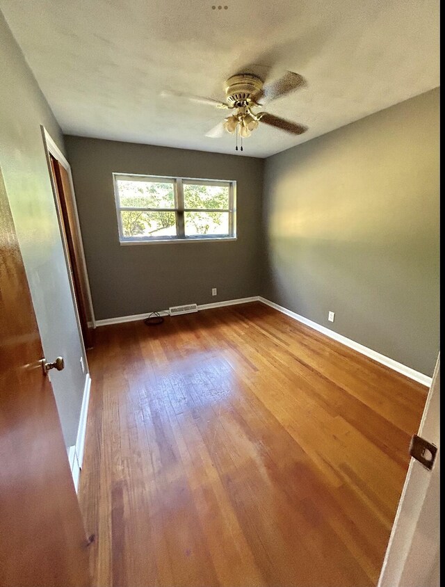 spare room with ceiling fan and wood-type flooring