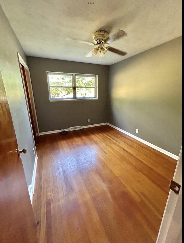 unfurnished bedroom featuring visible vents, baseboards, ceiling fan, wood finished floors, and a closet