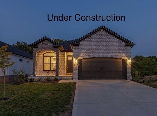 view of front facade with a garage, a front lawn, concrete driveway, and brick siding