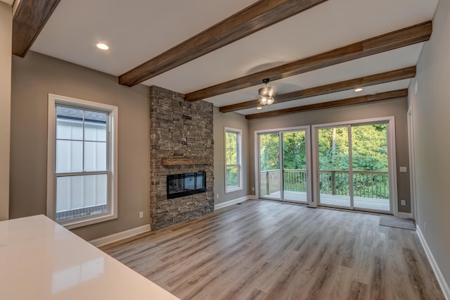 unfurnished living room with baseboards, a fireplace, and light wood-style floors