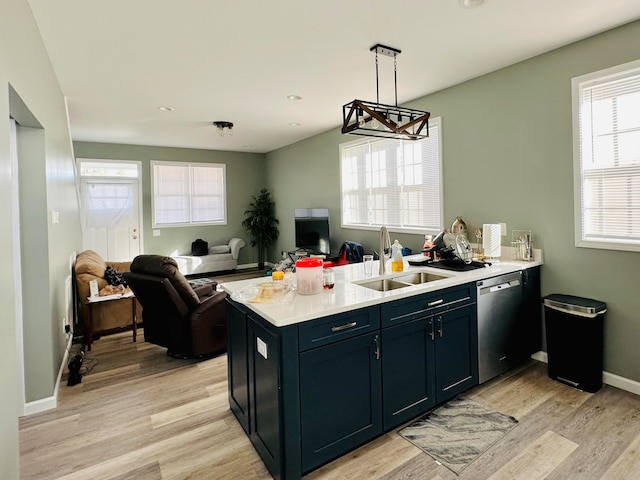 kitchen with pendant lighting, stainless steel dishwasher, sink, and light hardwood / wood-style floors