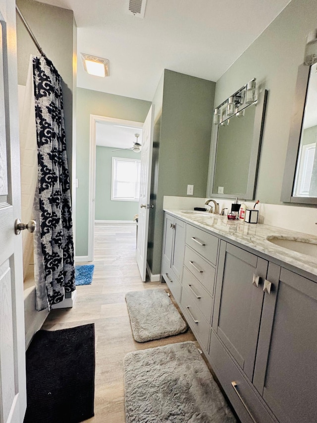 bathroom with vanity, hardwood / wood-style flooring, and shower / bath combo with shower curtain