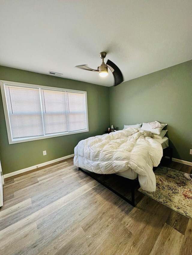 bedroom with ceiling fan and wood-type flooring