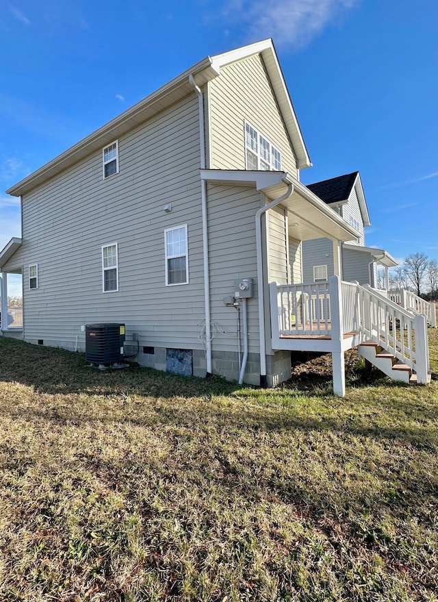 back of house with a wooden deck, central AC unit, and a yard