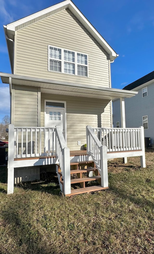 rear view of property featuring a lawn and a porch