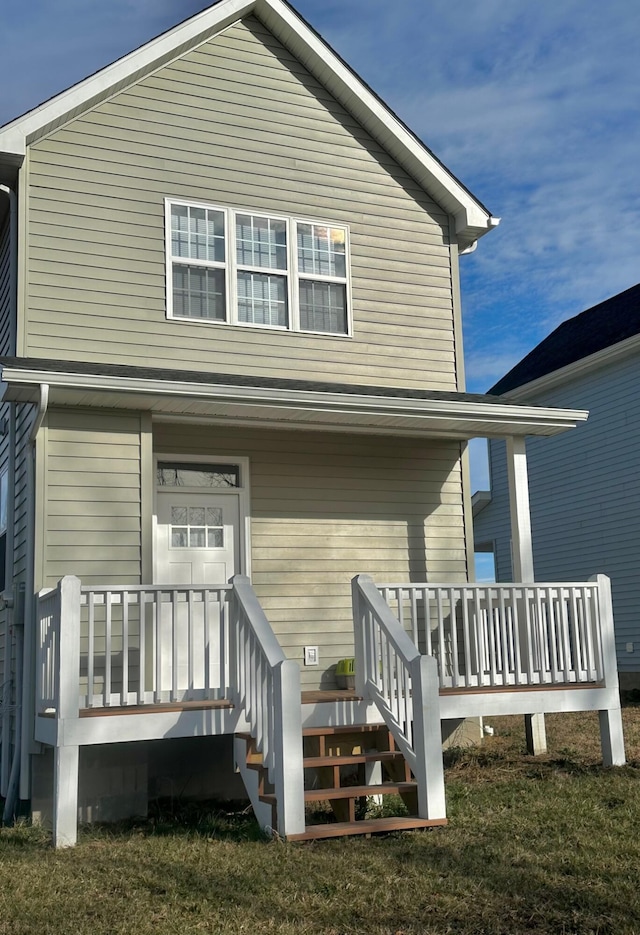 back of house featuring a lawn and a porch