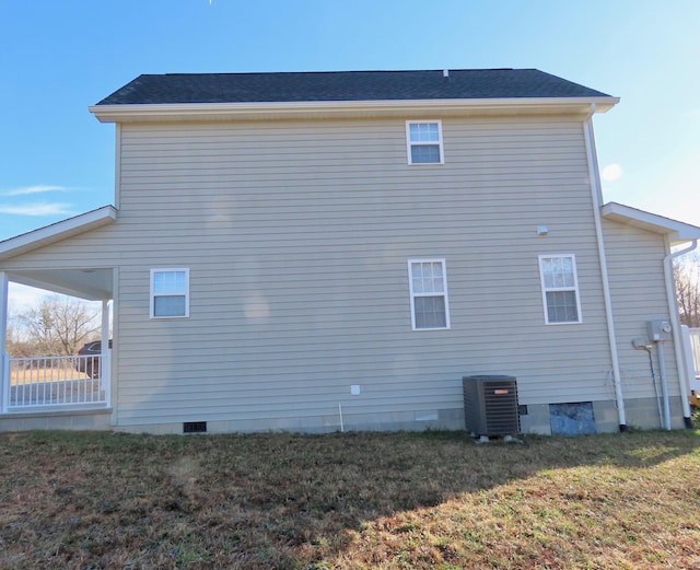 view of side of home featuring central air condition unit and a yard