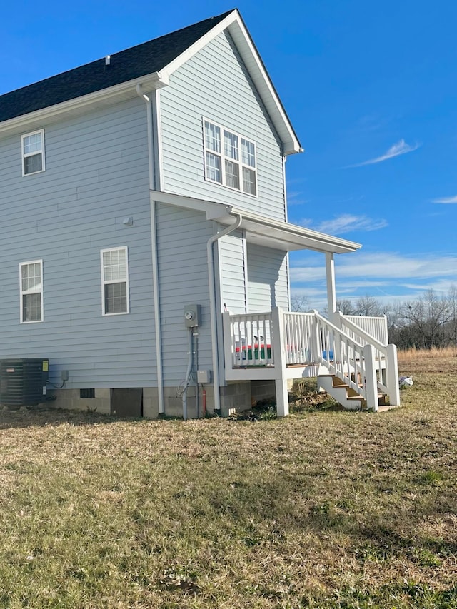 back of property featuring a lawn and central AC unit