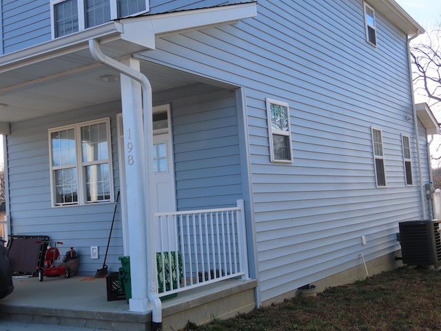 view of home's exterior with covered porch and central AC