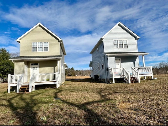 back of house featuring a lawn and covered porch