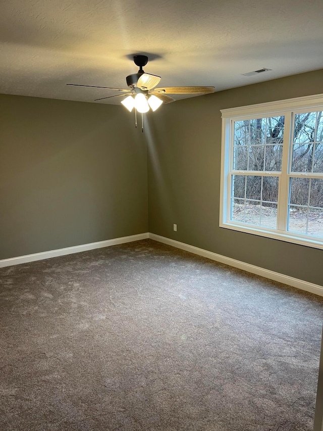 carpeted empty room featuring a healthy amount of sunlight and ceiling fan