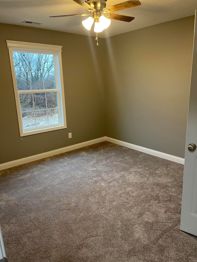 spare room featuring plenty of natural light, carpet, and ceiling fan