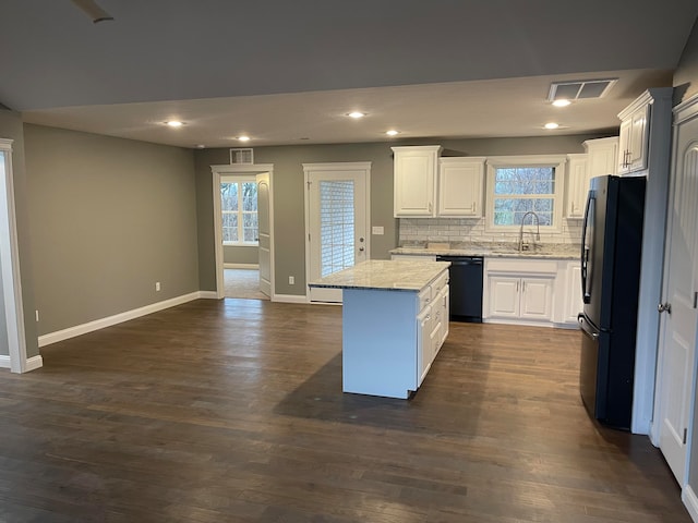 kitchen featuring black dishwasher, dark hardwood / wood-style floors, fridge, and white cabinets