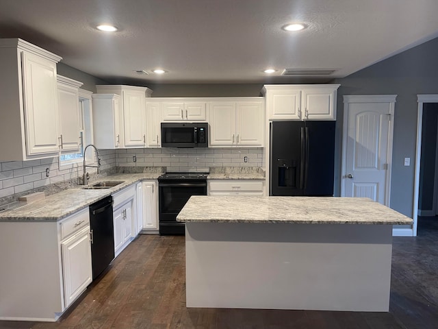 kitchen featuring white cabinets, a center island, black appliances, and sink