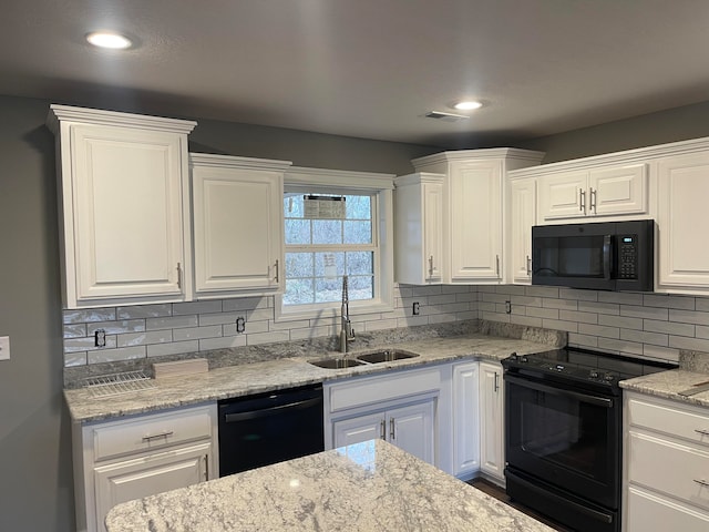 kitchen featuring white cabinets, backsplash, black appliances, and sink