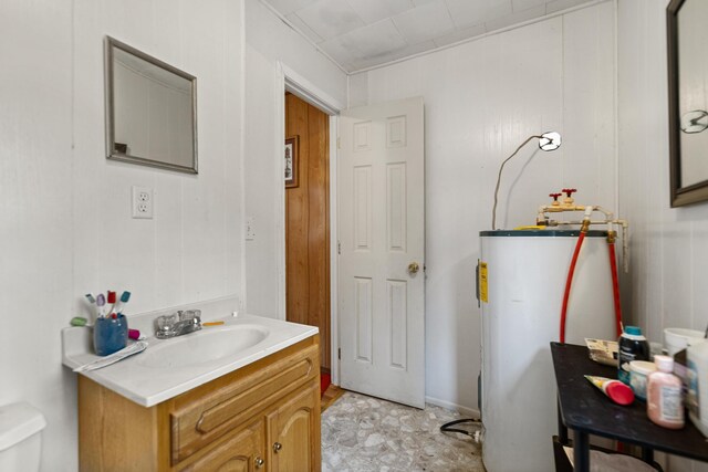 bathroom featuring tile patterned floors, gas water heater, toilet, and vanity