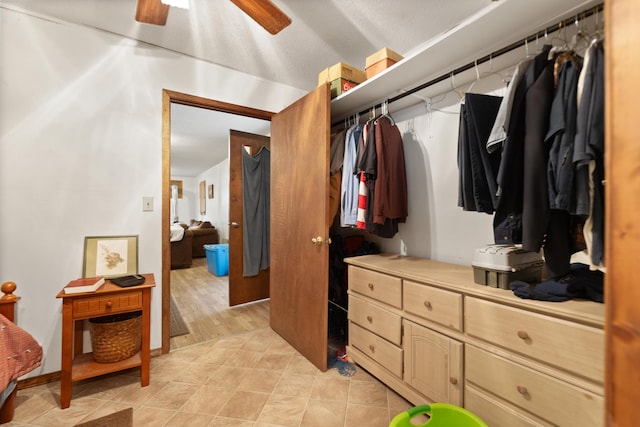 walk in closet with light tile patterned floors and ceiling fan