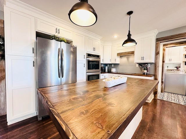 kitchen featuring stainless steel appliances, decorative light fixtures, dark hardwood / wood-style flooring, white cabinets, and washer / clothes dryer