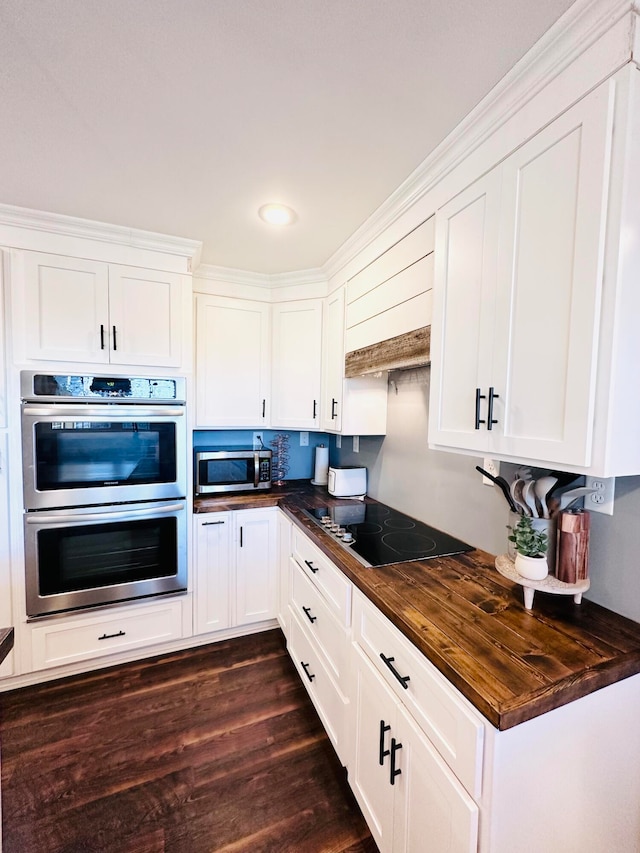 kitchen with white cabinets, stainless steel appliances, dark hardwood / wood-style flooring, and wooden counters