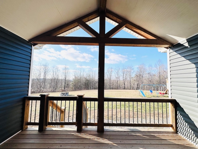 wooden deck with a playground and a yard