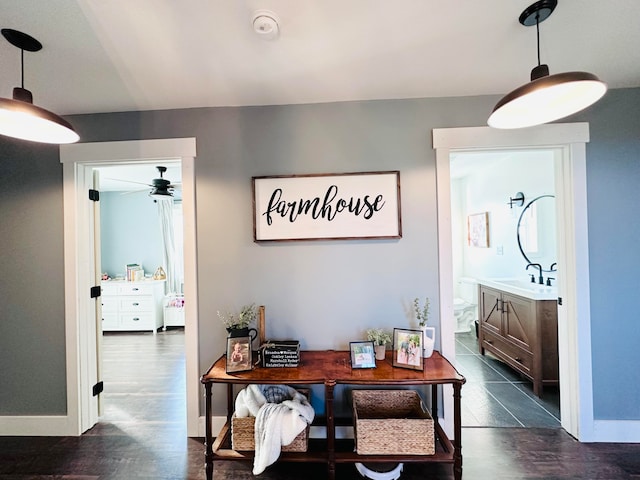 interior space featuring dark wood-type flooring, ceiling fan, and sink