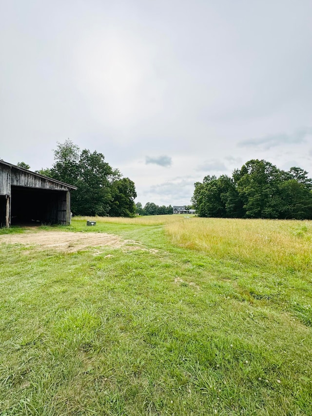 view of yard with an outbuilding and a rural view