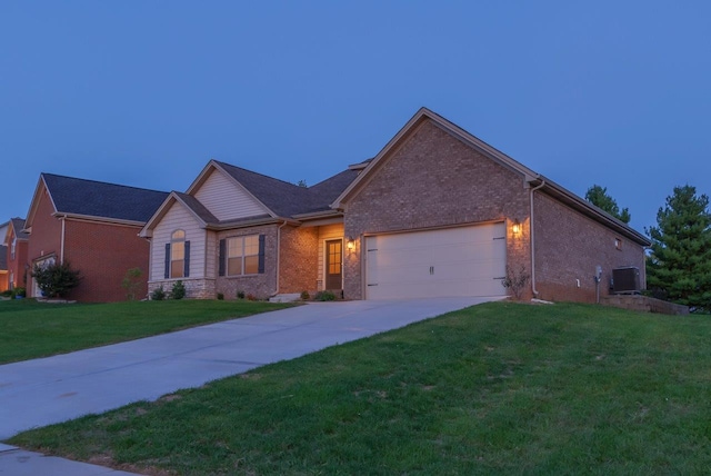 view of front of home with cooling unit, a garage, and a yard