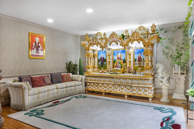 living room with ornamental molding, hardwood / wood-style flooring, and a textured ceiling