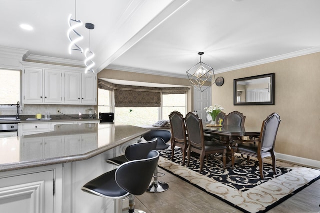 dining area with ornamental molding, a chandelier, and beamed ceiling