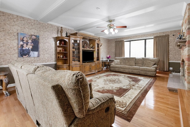 living room featuring ceiling fan, light wood-type flooring, and crown molding