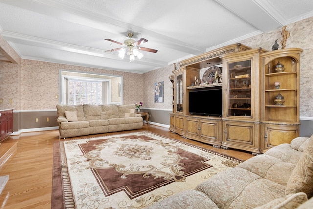 living room featuring light hardwood / wood-style floors, ceiling fan, a textured ceiling, and beam ceiling