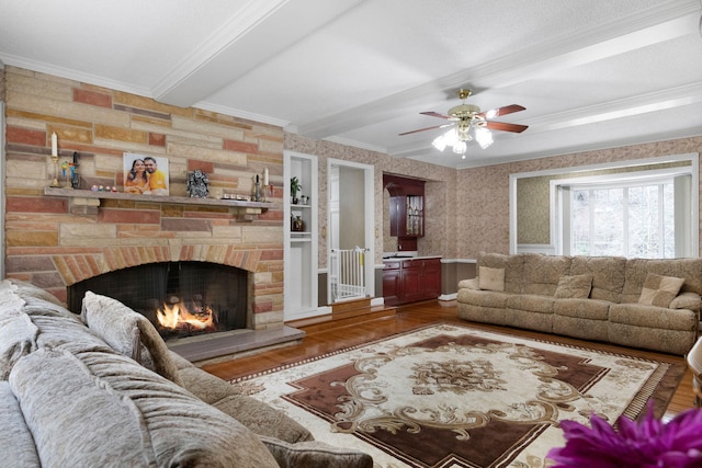 living room featuring beam ceiling, a fireplace, ceiling fan, a textured ceiling, and dark hardwood / wood-style flooring