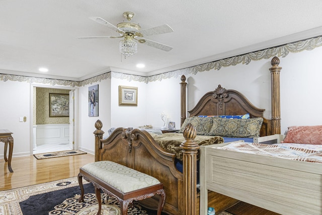 bedroom featuring ceiling fan, crown molding, and wood-type flooring