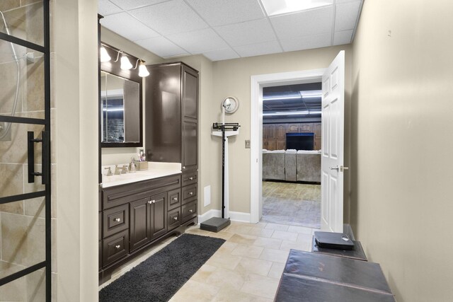 bathroom featuring a drop ceiling, tile floors, and vanity