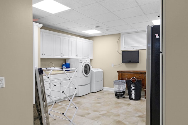 laundry area with light tile floors, cabinets, and independent washer and dryer