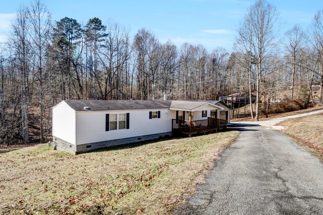 view of front facade featuring a wooden deck and a front lawn