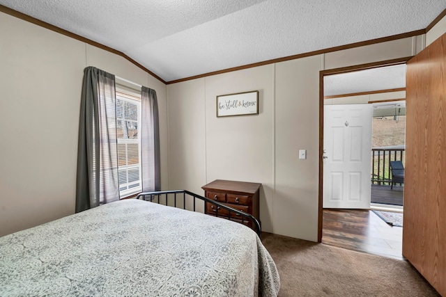 bedroom featuring a textured ceiling, vaulted ceiling, dark colored carpet, and multiple windows