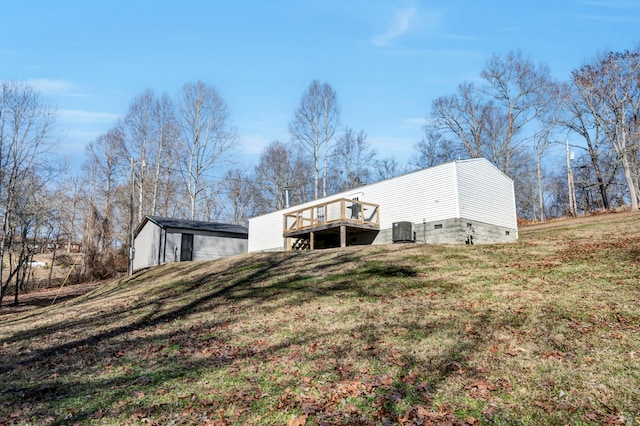 rear view of property with a deck and a lawn