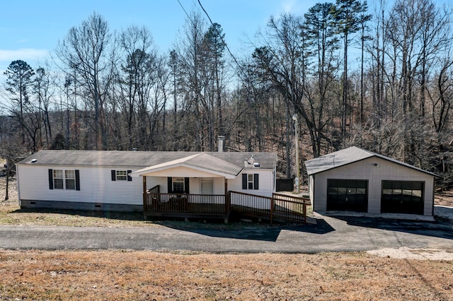 view of front of property featuring a wooden deck, an outdoor structure, and a garage