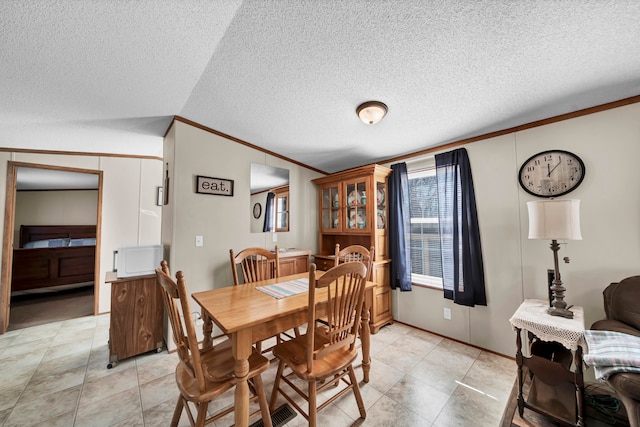 tiled dining room with crown molding and a textured ceiling