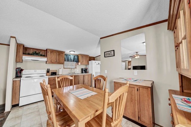 dining room featuring ceiling fan, a textured ceiling, sink, and light tile flooring