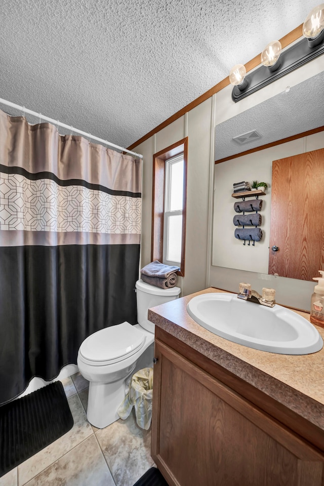 bathroom featuring toilet, tile floors, a textured ceiling, and vanity