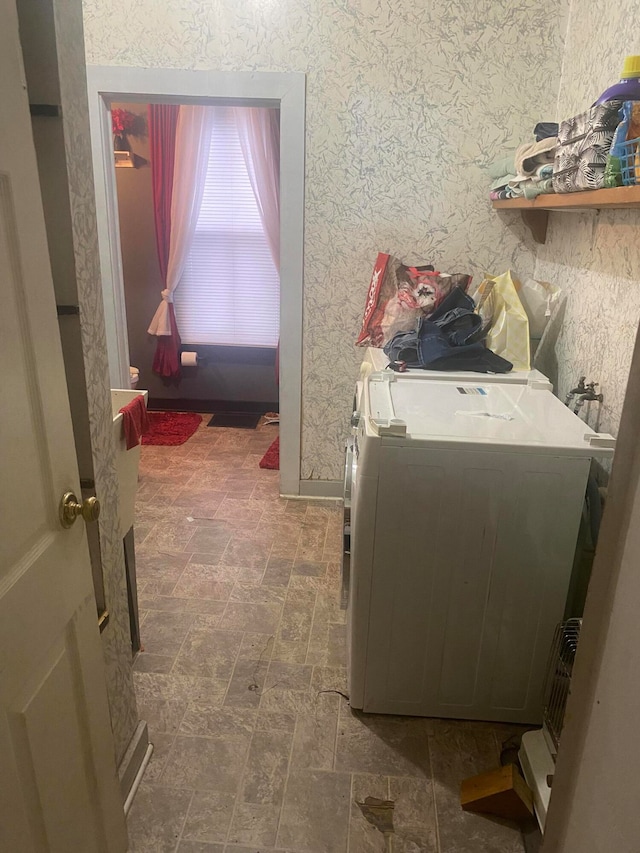 washroom with washing machine and clothes dryer and dark tile flooring