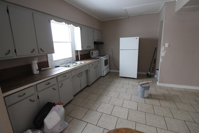 kitchen with white appliances, white cabinets, sink, and light tile flooring