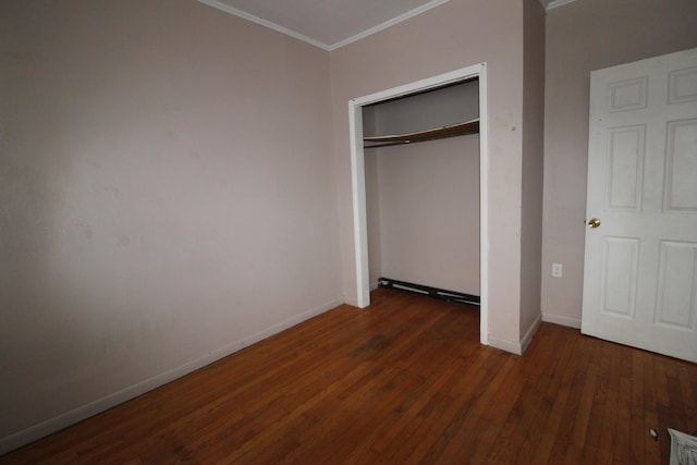 unfurnished bedroom with a closet, ornamental molding, and dark hardwood / wood-style floors