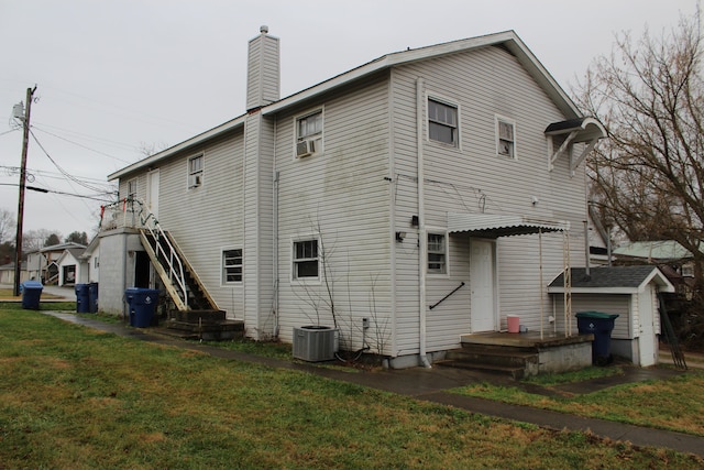 rear view of property featuring central AC and a yard