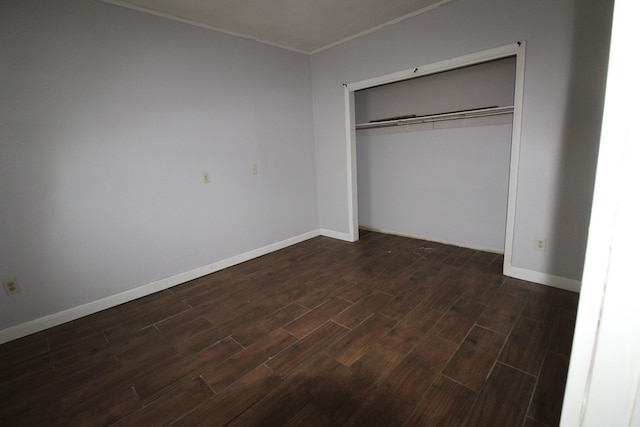 unfurnished bedroom with a closet and dark hardwood / wood-style floors